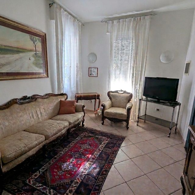 Soggiorno in stile classico con divano e televisore